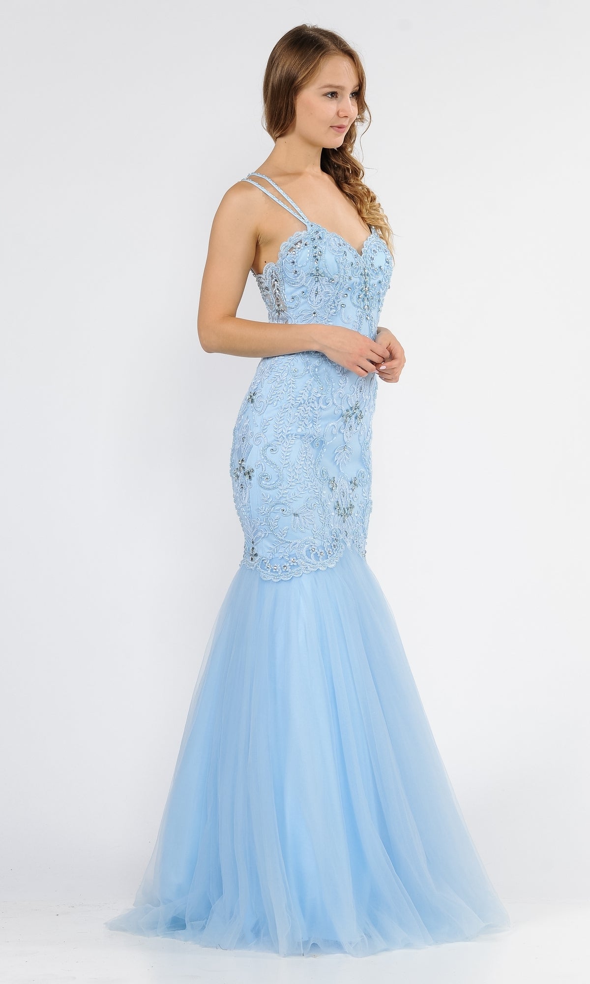 Woman in the Embroidered Tight Sweetheart Mermaid Prom Dress 8352, a light blue, floor-length gown with lace detailing and thin straps, stands against a plain white background.